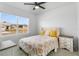 Bright bedroom featuring a ceiling fan, a cozy bed with decorative pillows, and a window with neighborhood views at 33436 Country House Dr, Sorrento, FL 32776