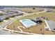 Aerial view of a large community swimming pool, clubhouse, and playground at 33436 Country House Dr, Sorrento, FL 32776