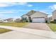 Exterior view of a well-maintained home with a brick driveway and manicured lawn in a suburban neighborhood at 33436 Country House Dr, Sorrento, FL 32776