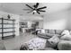 Bright, open-concept living room with gray sofa, modern decor, and tiled floors leading to a stylish kitchen at 33436 Country House Dr, Sorrento, FL 32776