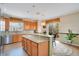 Well-lit kitchen with granite countertops, stainless steel appliances, and a breakfast bar overlooking the backyard at 3452 Goldeneye Ln, St Cloud, FL 34772