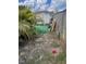 Backyard with a storage shed, green artificial turf, partial fencing, and mature landscaping at 350 Corsica Ct, Kissimmee, FL 34758