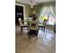 Dining room featuring glass table, four cream and wood chairs, tile flooring, and stylish chandelier at 350 Corsica Ct, Kissimmee, FL 34758