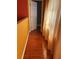 Hallway with hardwood floors, colorful accent wall, and natural light shining through the curtains at 350 Corsica Ct, Kissimmee, FL 34758
