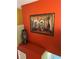 Upstairs hallway with bright orange wall and decorative framed artwork at 350 Corsica Ct, Kissimmee, FL 34758