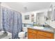 Well-lit bathroom with vanity, toilet, and shower with blue patterned curtain at 3741 Crossing Creek Blvd, St Cloud, FL 34772