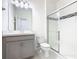 Modern bathroom featuring a glass door shower, vanity with a white marble countertop, and gray cabinets at 417 Tisone Ln, Davenport, FL 33837