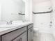 Modern bathroom with double vanity, framed mirror, and shower-tub combination with black accent tiles at 417 Tisone Ln, Davenport, FL 33837