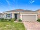 Charming single-story home with a brick driveway, a two-car garage, and blue shutters at 417 Tisone Ln, Davenport, FL 33837