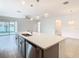 Kitchen with stainless steel dishwasher, gray cabinets, an eat-in bar, and view to living area at 417 Tisone Ln, Davenport, FL 33837