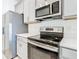 Close-up on stainless steel appliances and gray cabinets in modern kitchen with countertop at 417 Tisone Ln, Davenport, FL 33837