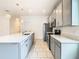 Gray kitchen cabinets and stainless steel appliances complement a center island with pendant lighting above at 417 Tisone Ln, Davenport, FL 33837