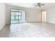 Bright living room with tile flooring, ceiling fan, and sliding doors to the outdoor patio at 417 Tisone Ln, Davenport, FL 33837