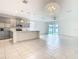 Open floor plan kitchen with stainless appliances, island, and pendant lights to the Gathering room with sliding doors at 417 Tisone Ln, Davenport, FL 33837