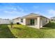 View of the backyard featuring a well-maintained lawn and covered patio area at 444 Lily Ln, Davenport, FL 33837