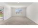 Bright bedroom featuring neutral carpet, a window, and a closet door with white trim at 444 Lily Ln, Davenport, FL 33837