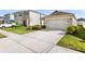 Well-manicured front yard of a single-story house featuring a two-car garage at 444 Lily Ln, Davenport, FL 33837