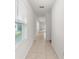 A bright hallway with tile floors, white walls, and natural light streaming through the window at 444 Lily Ln, Davenport, FL 33837