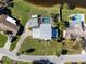 Aerial view of a property with a screened pool, covered parking, and a well-manicured lawn at 4500 Lake Trudy Dr, St Cloud, FL 34769