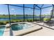 The screened-in lanai has a spa overlooking a serene view of the lake at 4807 Kings Castle Cir, Kissimmee, FL 34746