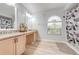 Bathroom with double vanity, granite counters, and a shower with patterned shower curtain at 5113 Sage Way, Kissimmee, FL 34758