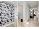 View of shower with patterned curtain with hallway leading to bedroom with four-poster bed at 5113 Sage Way, Kissimmee, FL 34758