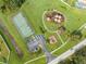 Aerial view of tennis court and playground with picnic tables in green common area at 5113 Sage Way, Kissimmee, FL 34758