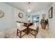 Inviting dining area with rug, modern chandelier, and seating for four next to a large plant at 5113 Sage Way, Kissimmee, FL 34758