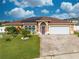 Charming single-story home with a well-manicured lawn, brick driveway, and solar panels on the roof at 5113 Sage Way, Kissimmee, FL 34758