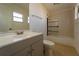 Bright bathroom features neutral-toned vanity, shower with glass door and decorative tiling at 5445 Marvell Ave, Orlando, FL 32839