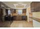 Charming kitchen featuring dark wood cabinetry, granite countertops, and modern black appliances at 5445 Marvell Ave, Orlando, FL 32839