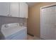 Practical laundry area featuring storage cabinets and a white washing machine at 5445 Marvell Ave, Orlando, FL 32839