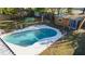 Aerial view of a kidney-shaped pool with a white concrete surround and a wood shed in a fenced yard at 5445 Marvell Ave, Orlando, FL 32839