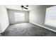 Spacious bedroom with plush carpeting, ceiling fan, and two large windows offering plenty of natural light at 553 Viceroy Ct, Kissimmee, FL 34758