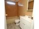 Standard bathroom with tub, light wood-tone surround, neutral wall color and basic white vanity at 6332 Bayberry Ne Blvd, Winter Haven, FL 33881