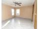 Bright bedroom featuring sleek gray floors, neutral paint, ceiling fan and natural light at 6332 Bayberry Ne Blvd, Winter Haven, FL 33881
