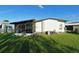 Rear exterior featuring a screened-in porch and a well-manicured lawn at 6332 Bayberry Ne Blvd, Winter Haven, FL 33881