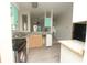 Galley kitchen featuring stainless steel sink, black range and wood-look tile flooring at 6332 Bayberry Ne Blvd, Winter Haven, FL 33881
