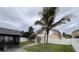 Scenic backyard view featuring shed, covered patio, palm tree, and white fence at 6410 Cherry Grove Cir, Orlando, FL 32809