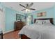 Comfortable bedroom with light blue walls, ceiling fan, and wood flooring at 6410 Cherry Grove Cir, Orlando, FL 32809