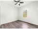 A simple bedroom with hardwood flooring, a ceiling fan, and a window to allow natural light in at 6430 Sw 144Th Street Rd, Ocala, FL 34473