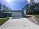 The house includes a large garage, lengthy drive way, and manicured lawn at 6430 Sw 144Th Street Rd, Ocala, FL 34473