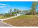 This single-story home features a long driveway that slopes up to a two-car garage at 6430 Sw 144Th Street Rd, Ocala, FL 34473