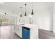 Bright kitchen with a white island, sleek countertops, stainless steel sink, and an eye-catching blue dishwasher at 6430 Sw 144Th Street Rd, Ocala, FL 34473