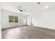 Inviting living room with an outdoor view, modern ceiling fan, and wood-look floors at 6430 Sw 144Th Street Rd, Ocala, FL 34473