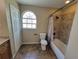 A well-lit bathroom features a bathtub, tiled shower, toilet, and window for natural light at 713 Illinois Ave, St Cloud, FL 34769