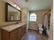 Bathroom featuring a vanity with a large framed mirror, and a shower-tub combo at 713 Illinois Ave, St Cloud, FL 34769