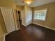 A cozy bedroom features hardwood floors, a window for natural light, and closet for storage at 713 Illinois Ave, St Cloud, FL 34769