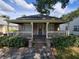 Charming single-story home featuring a cozy front porch with wood flooring and brick steps at 713 Illinois Ave, St Cloud, FL 34769