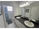 The bathroom has a double vanity with white cabinets and tile flooring at 723 Tuscan Hills Blvd, Davenport, FL 33897